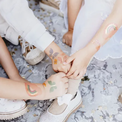 Crianças com tatuagens temporárias coloridas nos braços e sapato infantil prateado brilhante