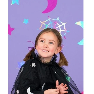 Menina com capa preta com estrelas e luas e fundo roxo com imagens coloridas