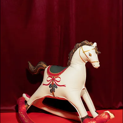 Cavalo de balanço decorativo em tons creme, castanho, vermelho e dourado