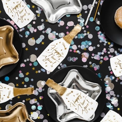 Pratos estrela dourados e prateados com cartões Happy New Year e confetes coloridos