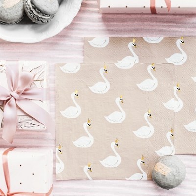 Presentes embrulhados com papel branco e rosa, papel estampado com cisnes e macarons cinzentos