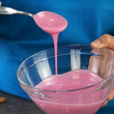 Colher a verter líquido cor-de-rosa num recipiente de vidro