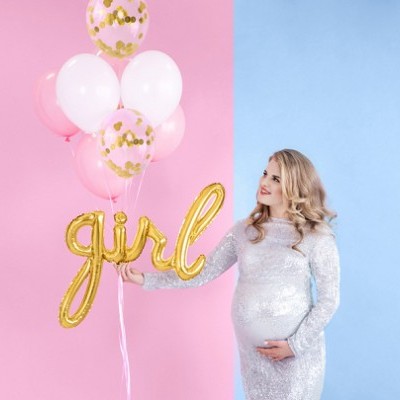 Mulher grávida segura balões coloridos em fundo rosa e azul