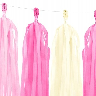 Detalhes decorativos de papel rosa e branco pendurados numa linha