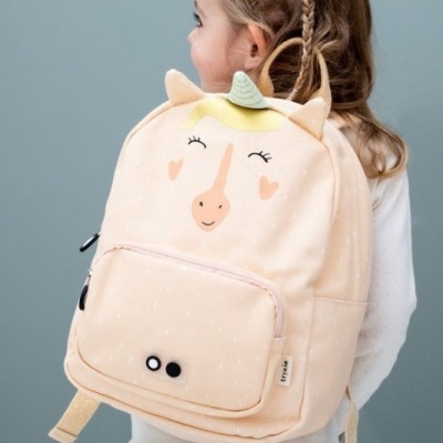 Mochila infantil bege com design de unicórnio usada por criança de perfil