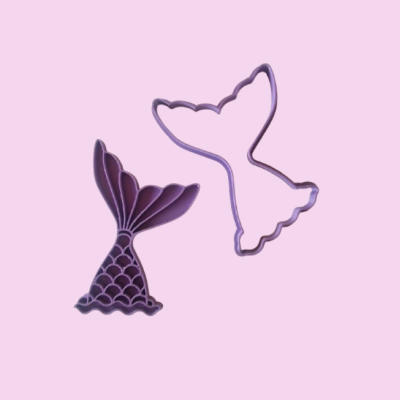 Cortadores de biscoitos em forma de rabo de sereia roxos sobre fundo rosa