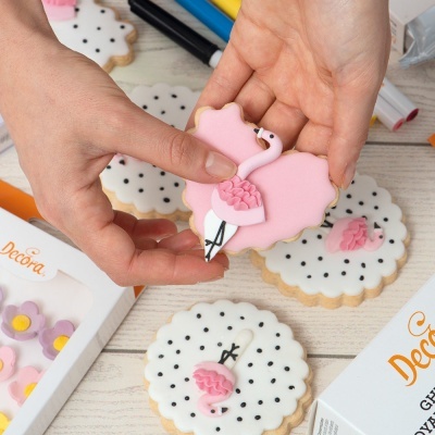 Biscoitos decorados em forma de cisne e redondos com glacê, embalagens Decora no fundo