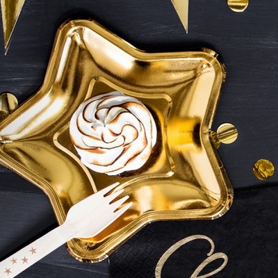 Prato dourado em forma de estrela com bolo e garfo de madeira