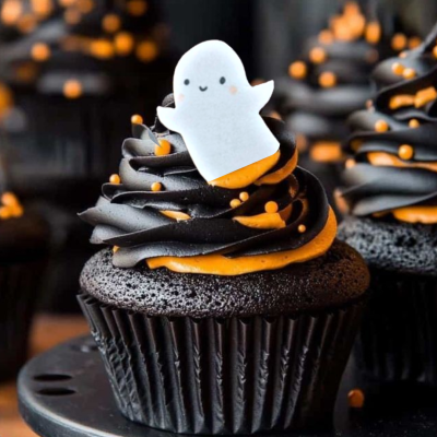 Cupcake de chocolate decorado com creme preto e laranja e fantasma de açúcar
