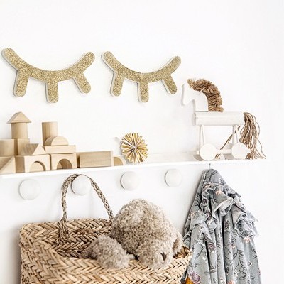 Decoração e organização de parede infantil com blocos de madeira, brinquedo cavalo, ganchos, cesta de vime e casaco floral