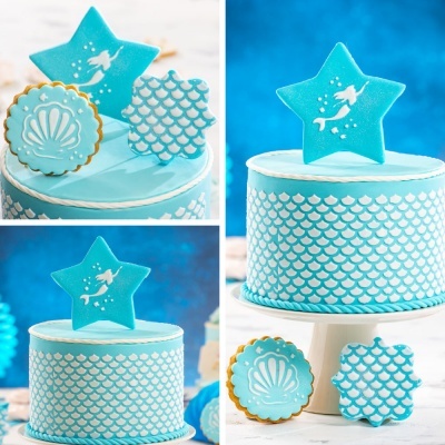bolo azul com padrão de escamas e estrela decorativa com sereia, biscoitos decorados