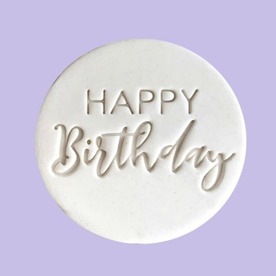 Disco redondo branco com gravação 'HAPPY Birthday' em relevo sobre fundo lilás.