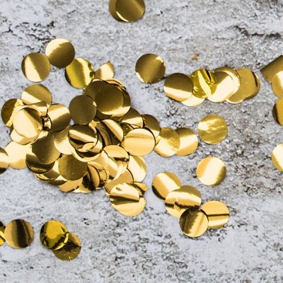 Confetes dourados redondos sobre superfície cinzenta