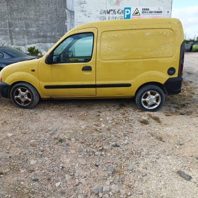 Carrinha amarela de lado com sinais de aviso em português ao fundo