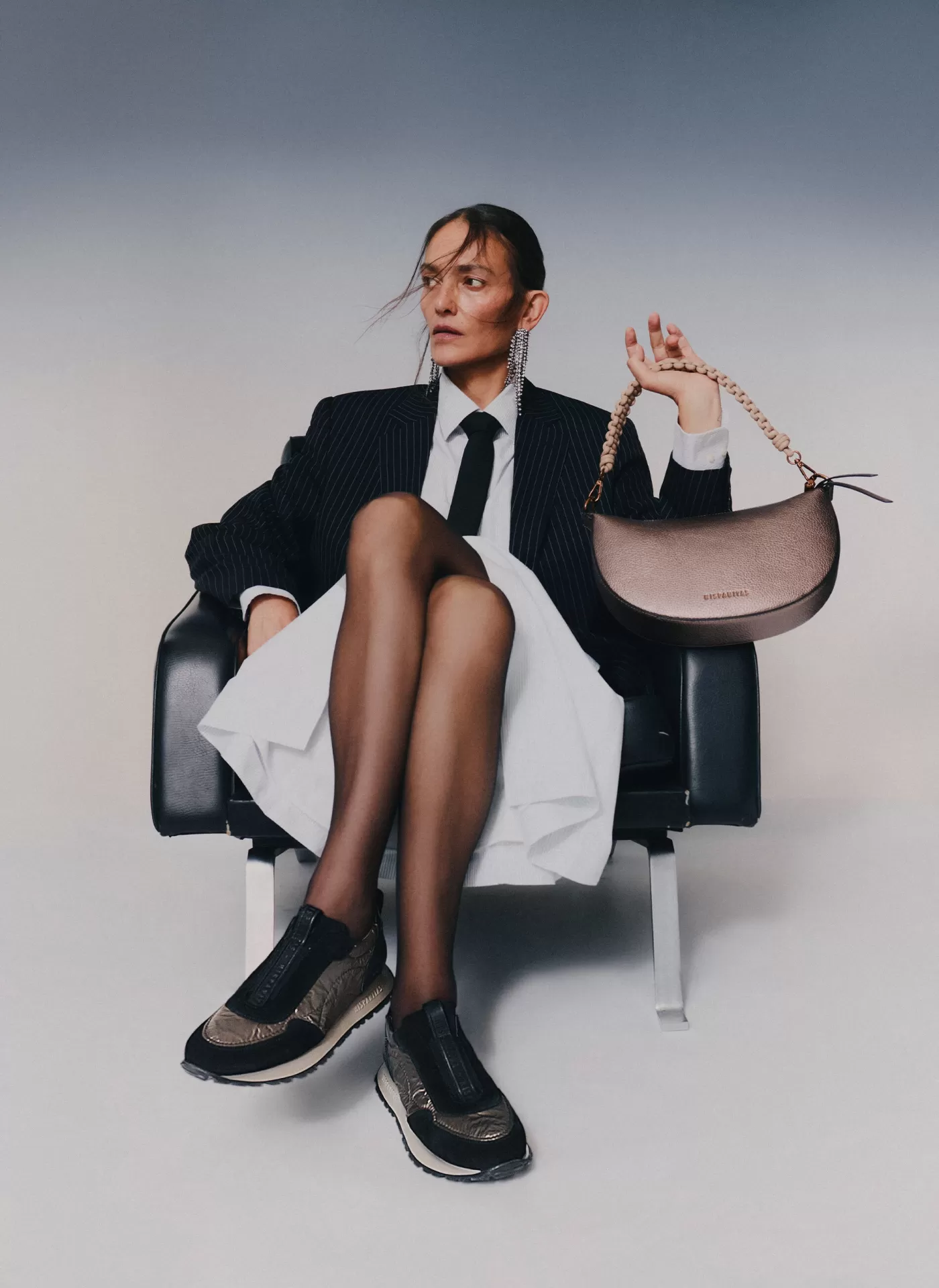 Sapatilha Hispanitas HV254222 Black/Taupe Mulher vestida formalmente com blazer e gravata, a segurar mala castanha com alça em correntes douradas