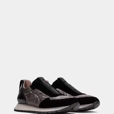 Sapatilhas de desporto cinza e preto com detalhes em veludo e sola branca.