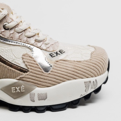 Sapatilha sneakers bege com detalhes de tecido e sola preta, marca EXÉ visível