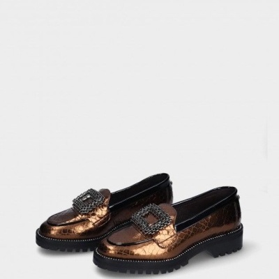 Sapatos mocassim castanhos metálicos com fivelas pretas sobre fundo cinzento