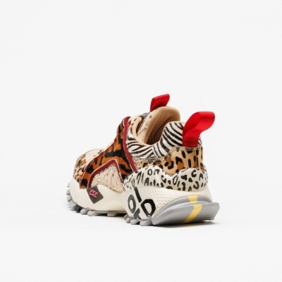 Tênis multicolorido com padrão animal print apontando para trás sobre fundo branco