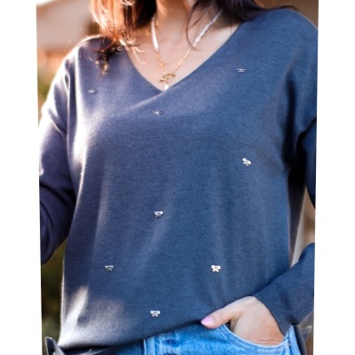 Camisola cinzenta de malha com detalhes metálicos prateados distribuídos uniformemente