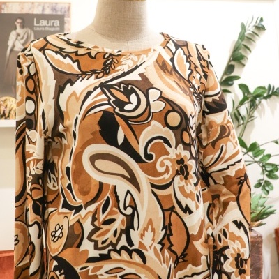 Camisola comprida com padrão abstrato castanho e bege num manequim