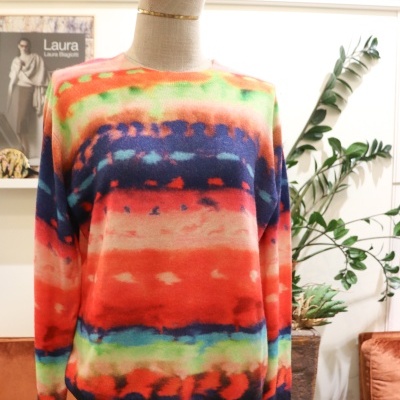 Camisola colorida tie-dye num manequim junto a plantas