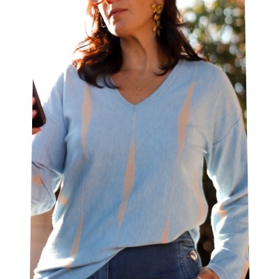 Camisola azul clara com padrão bege e gola em V num ambiente exterior