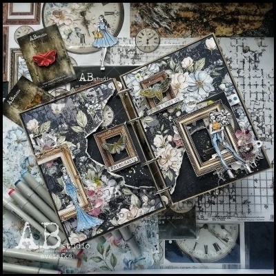 Caderno de scrapbook decorado com flores, molduras douradas e recortes femininos sobre mesa com relógios e cartas