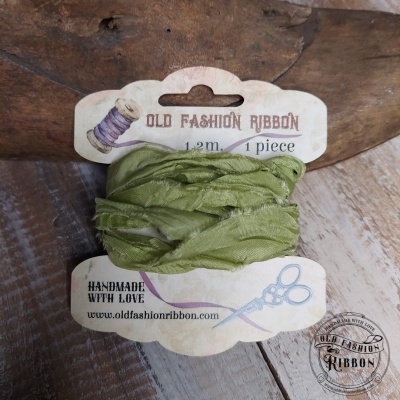 Fita de tecido verde clara em embalagem vintage sobre madeira rústica