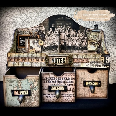Organizador vintage com gavetas decoradas com mapas e números, e foto antiga em preto e branco.