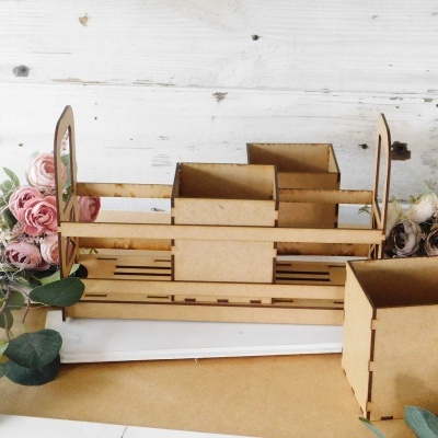 Organizadores de madeira castanha clara com divisórias e recipiente quadrado, decorados com flores ao fundo