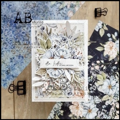 Cartão artesanal florido em relevo com texto em polaco sobre mesa de madeira