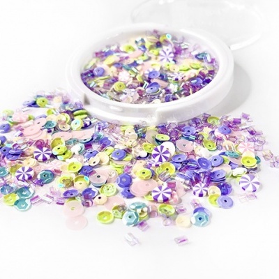 Sequins coloridos variados em recipiente transparente aberto