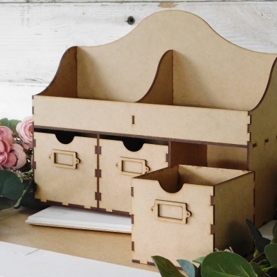 Organizador de madeira clara com gavetas e compartimentos em ambiente com flores