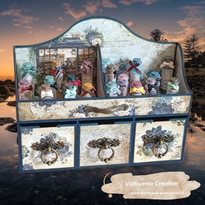 Organizador de madeira decorado com flores azuis e garrafas de vidro coloridas