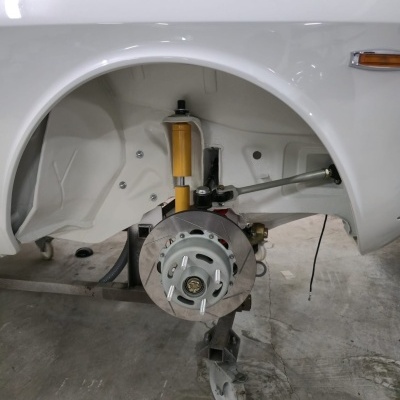 White vehicle wheel well with suspension and brake components