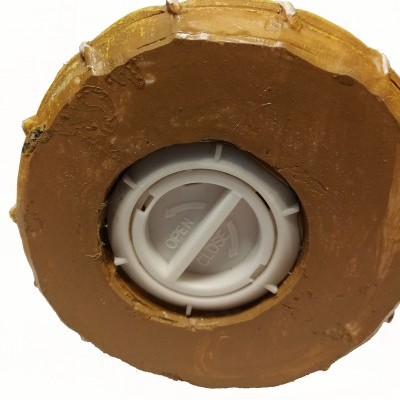 Fundo de objeto castanho com tampa branca rotativa com inscrições Open e Close