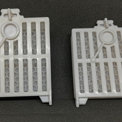 Dois filtros brancos de plástico com padrão de colmeia cinzenta e desenho de lupa