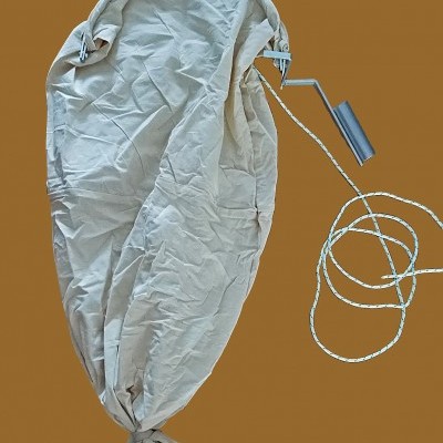 Saco cinzento claro com cordão branco e peça metálica cinzenta