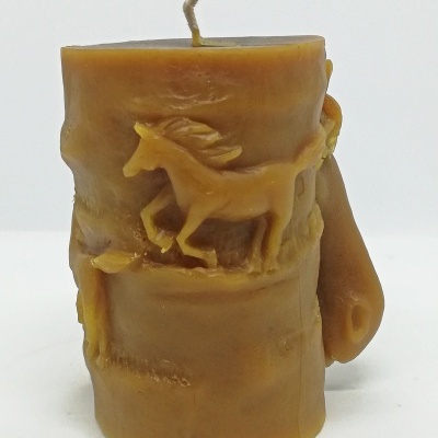 Vela amarela com relevo de cavalo e textura rugosa