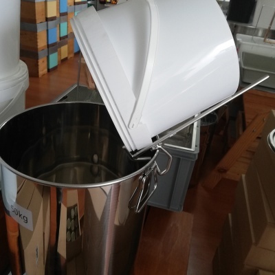 Balde branco inclinado sobre recipiente de aço inoxidável