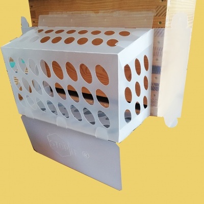 Caixa branca de papelão com orifícios e aba cinzenta sobre fundo amarelo