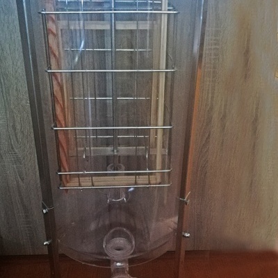 Garrafa transparente com suporte metálico e manivela vermelha