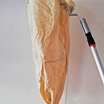 Saco de tecido bege amassado pendurado na parede