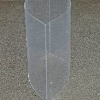 Estrutura plástica transparente cónica sobre superfície cinzenta