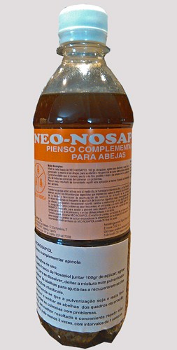 Frasco de plástico com líquido castanho e rótulo com texto em espanhol sobre suplemento para abelhas