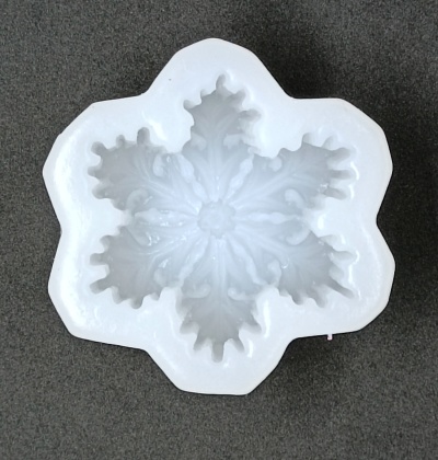 Molde branco em forma de floco de neve sobre fundo cinza escuro