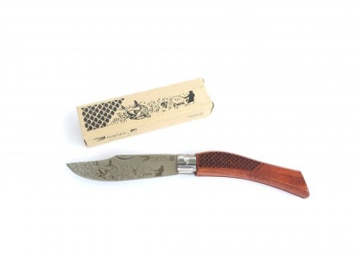 Faca com cabo de madeira e lâmina decorada ao lado de caixa de papelão