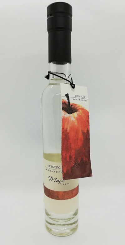 Garrafa de aguardente aessencia com rótulo e etiqueta com imagem de maçã vermelha