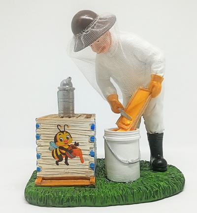 Estatueta de apicultor com quadro de mel e colmeia decorada com desenho de abelha